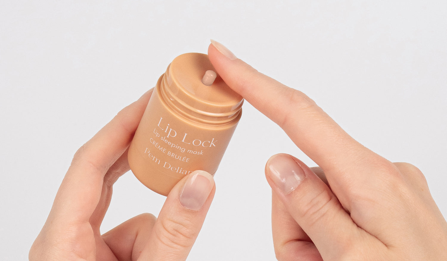 Pem Delian Lip Lock Créme Brulée éjszakai ajakápoló maszk kézben tartva kitekerve