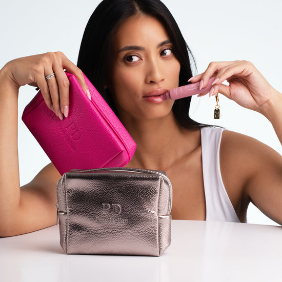 Pem Delian ezüst és pink sminktáska az asztalon, Iconic Lips Macaron a modell kezében használat közben