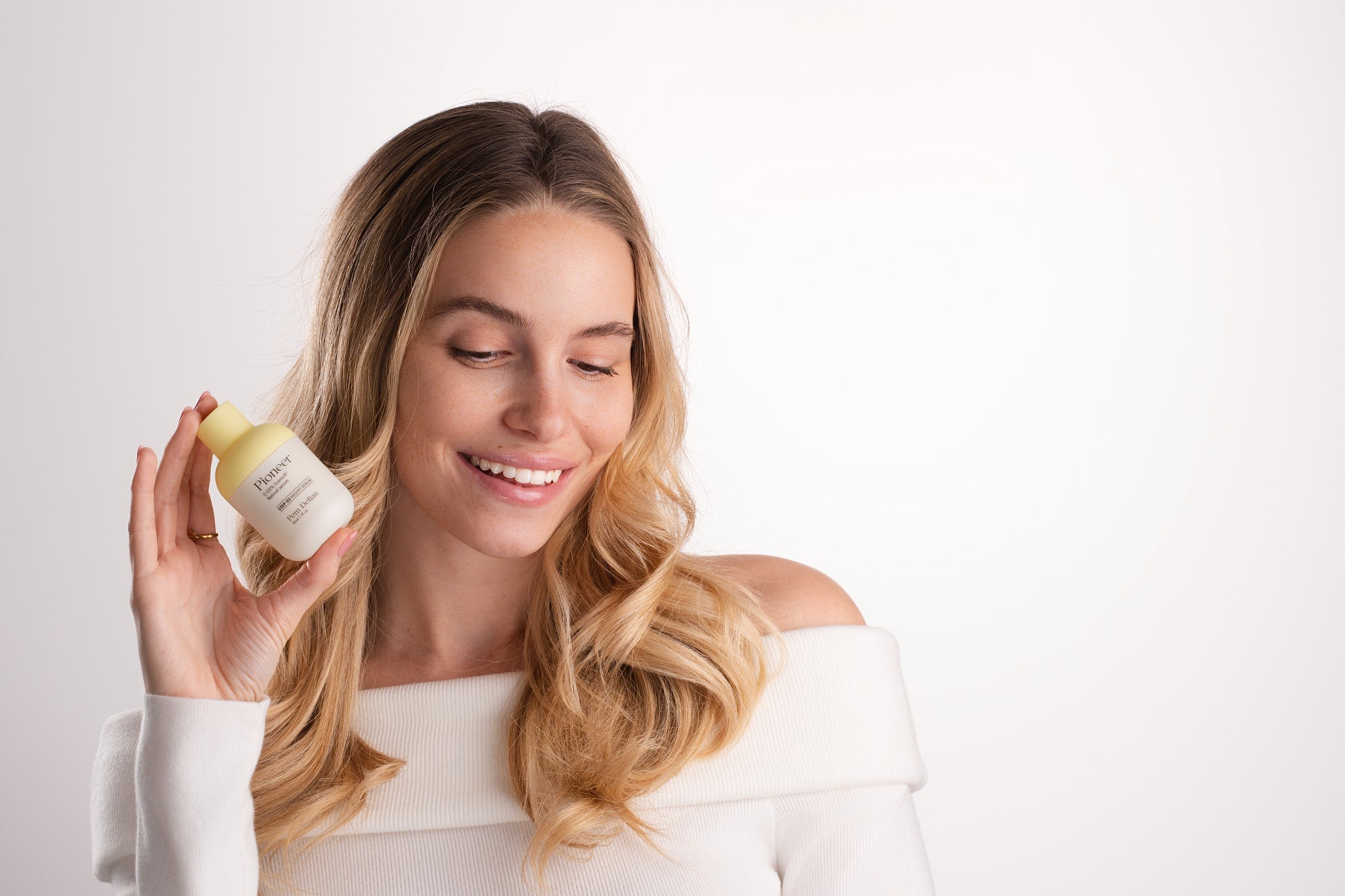 Pem Delian Pioneer retinal szérum mosolygó modell kezében aki lefelé néz fehér háttérrel