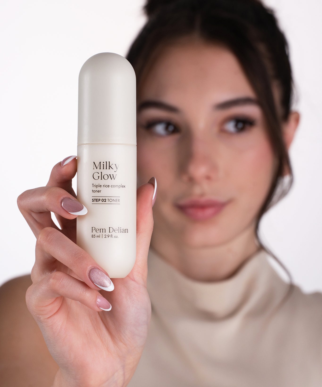 Pem Delian Milky Glow toner modell kezében tartva fókuszban homályos háttérrrel