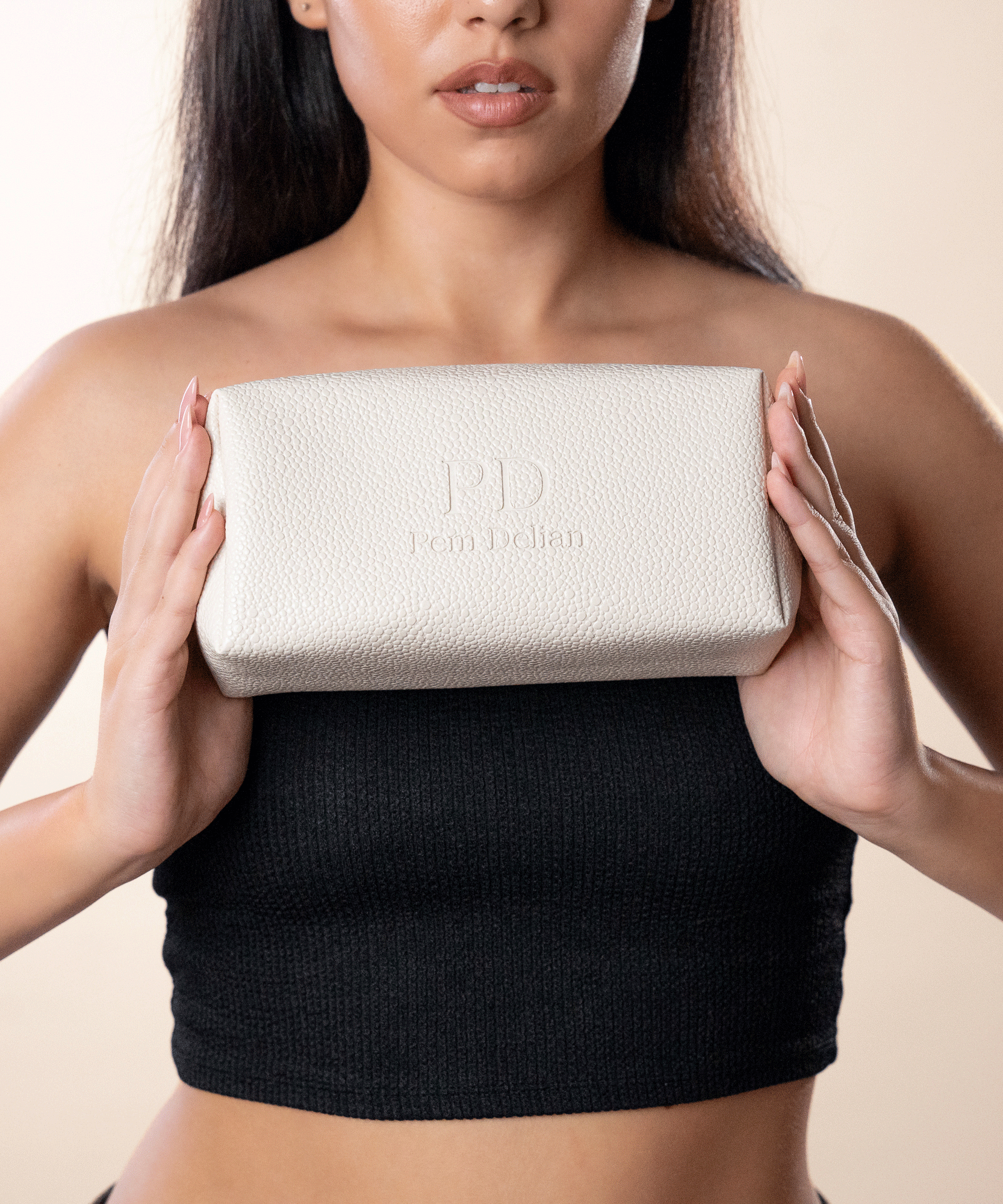 Pem Delian beige vegán bőr neszesszer
barna hajú modell kezében