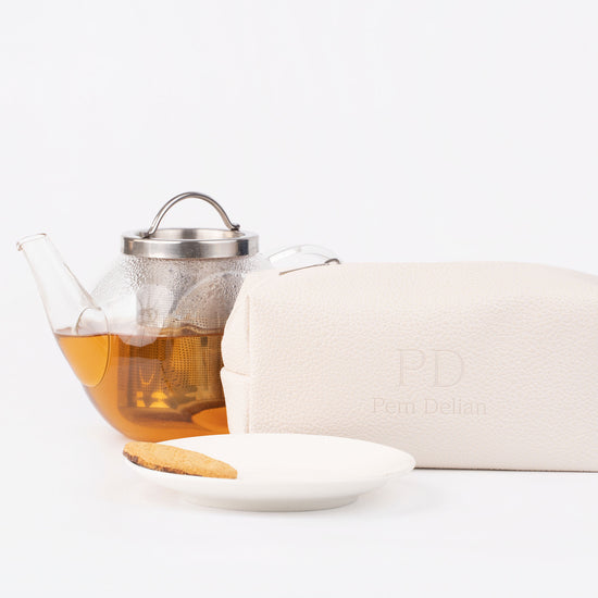 Pem Delian beige vegán bőr neszesszer, mellete tea, tányér és keksz