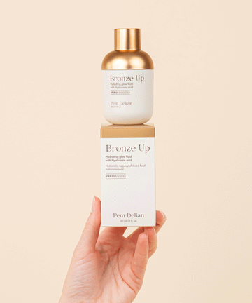 Pem Delian Bronze Up hidratáló, ragyogásfokozó fluid hialuronsavval
modell kezében dobozon tartva