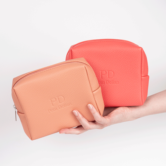 Pem Delian korall és barack színű vegán bőr sminktáska modell kezében