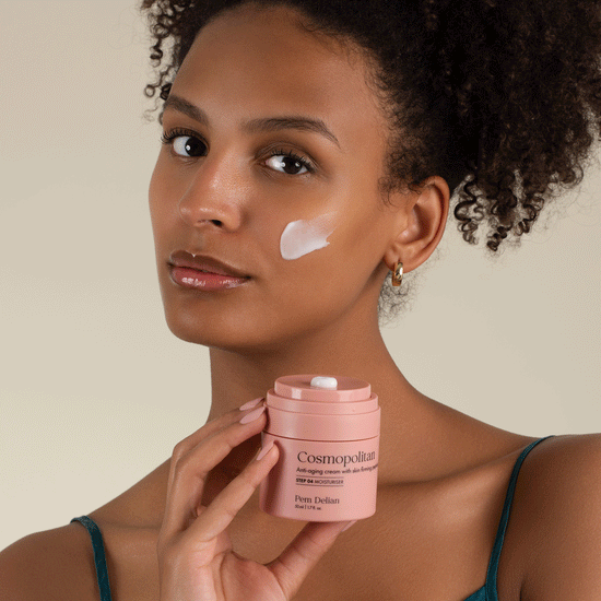 Pem Delian Cosmopolitan arckrém feszesítő peptidekkel a modell arcára kikenve, kezében a termék tégelye