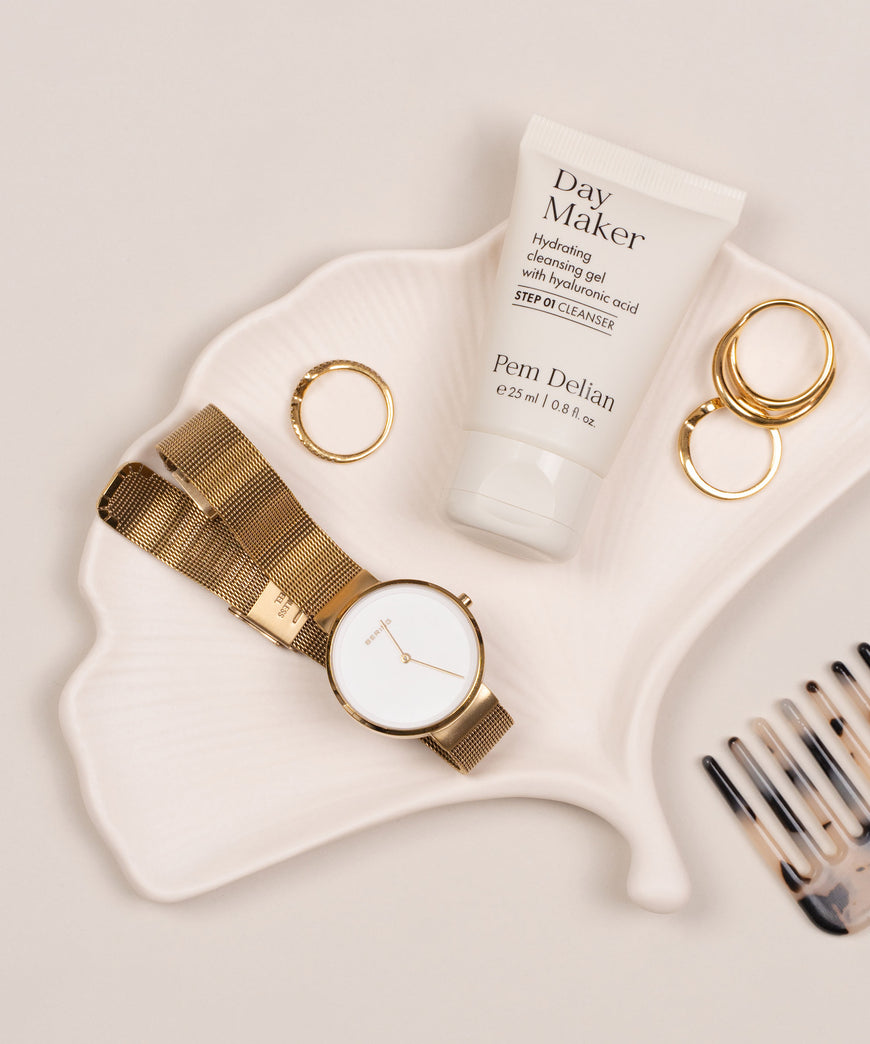 Mini Pem Delian Day Maker Hidratáló arctisztító gél hialuronsavval levél alakú tányéron, mellette gyűrűk, óra és fésű
