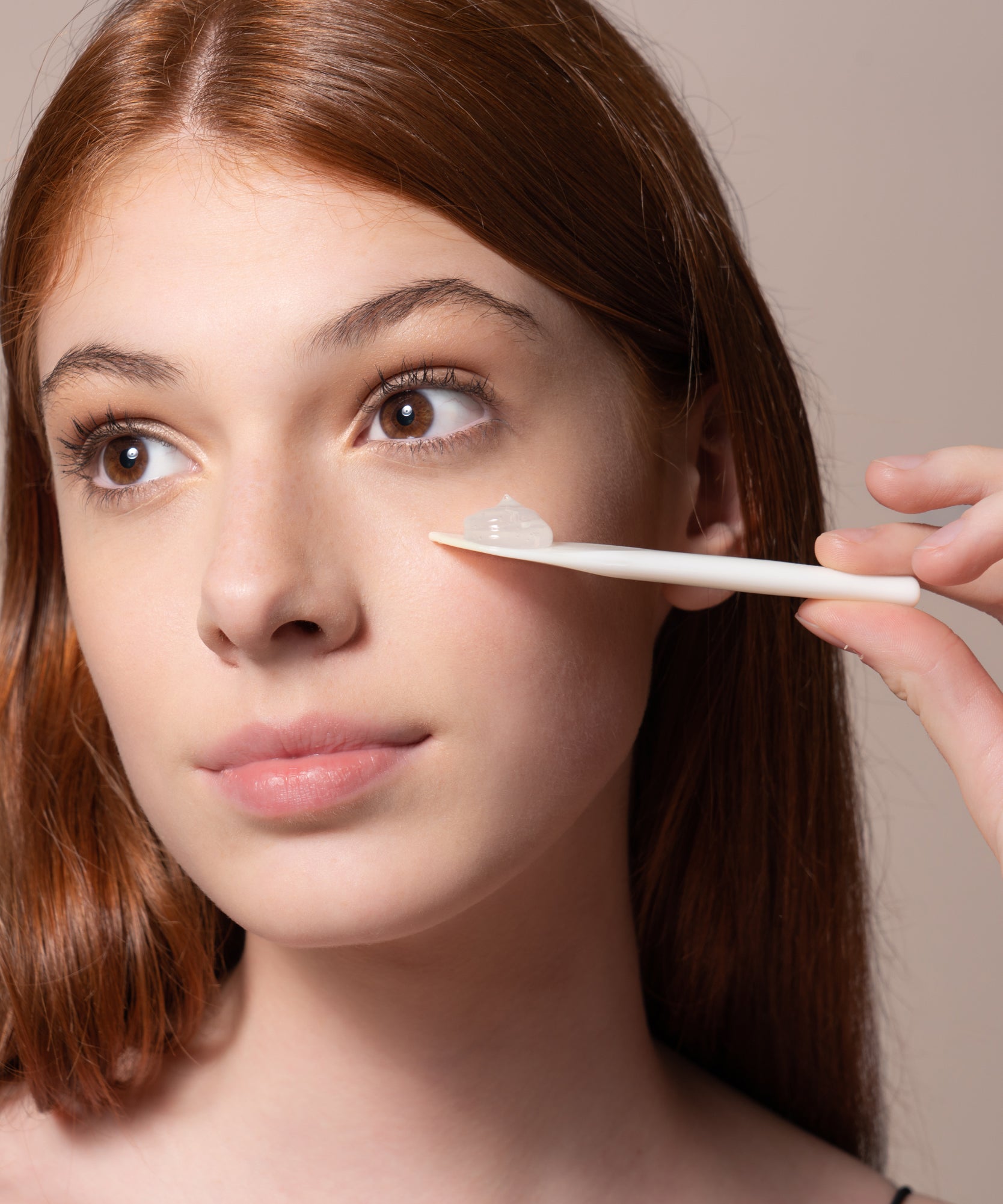 Pem Delian Day Maker Hidratáló arctisztító gél hialuronsavval textúrája egy spatulára kinyomva, a modell az arca elé tartja