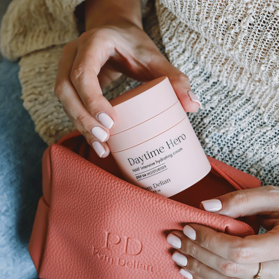 Pem Delian NMF intenzív hidratálókrémet a modell teszi bele a narancssárga színű kozmetikai táskába