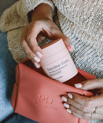 Pem Delian NMF intenzív hidratálókrémet a modell teszi bele a narancssárga színű kozmetikai táskába