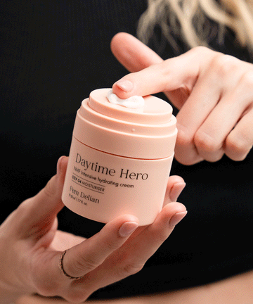 Pem Delian NMF intenzív hidratálókrémet a modell szétkeni a tégely tetején az ujjával