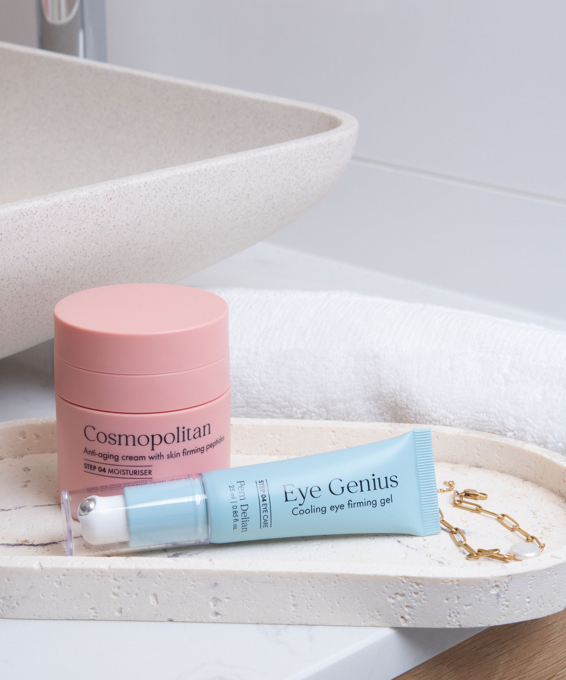 Pem Delian kozmetikumok, Eye Genius, Cosmopolitan fürdőszobában, tálcán mosdótál és törölköző előtt, karkötő mellett