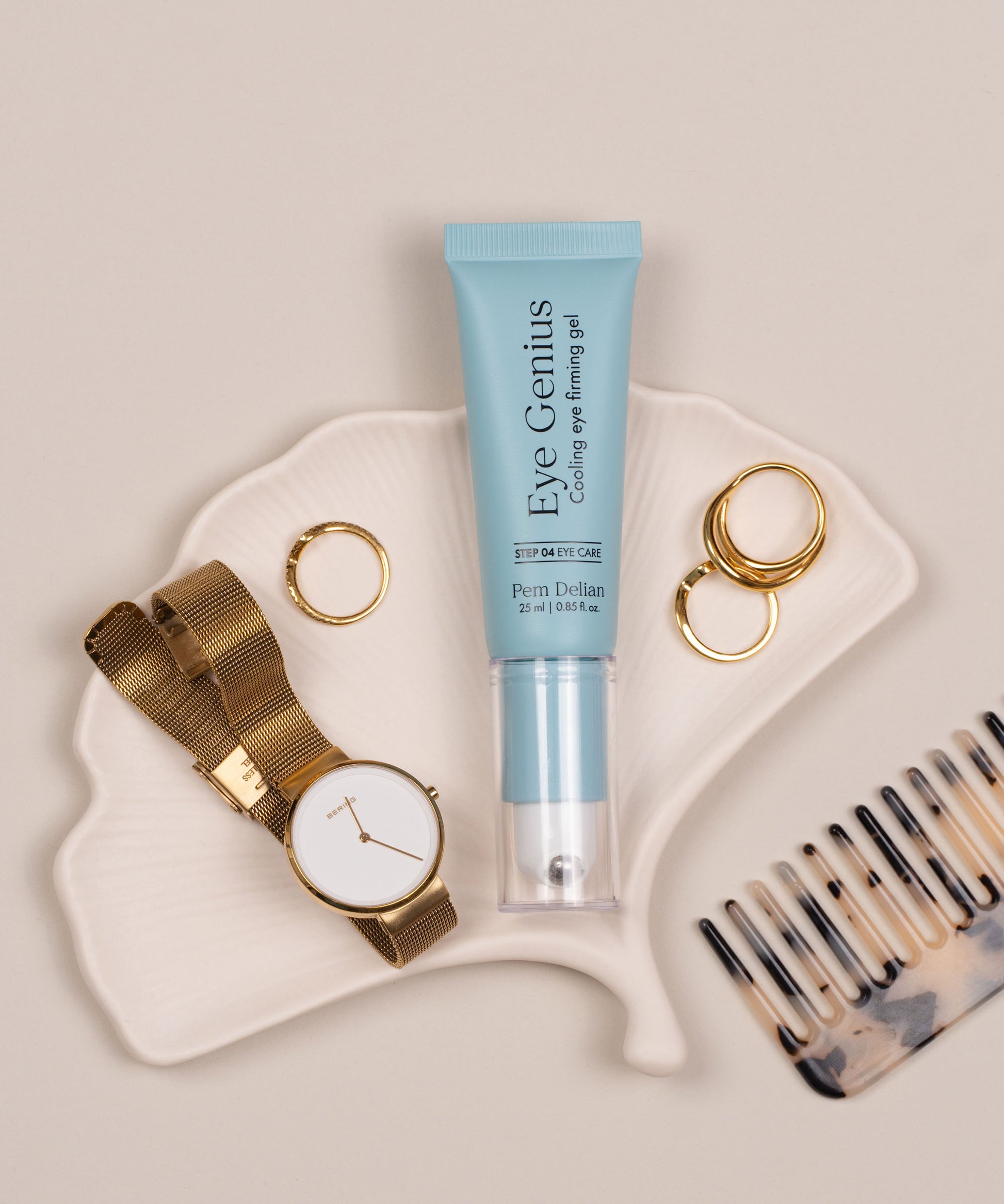 Pem Delian Eye Genius szemkörnyék feszesítő gél levél alakú tányéron, mellette óra, gyűrű, fésű