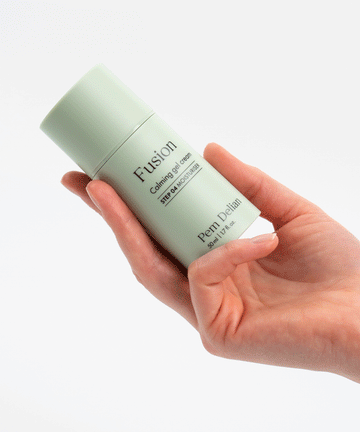 Pem Delian Fusion bőrnyugtató gélkrém ujjakkal tartva fehér háttér előtt