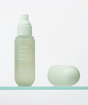 Pem Delian Glass Skin Ginseng & Centella toner üveg polcon, mellette fektetve a kupakja