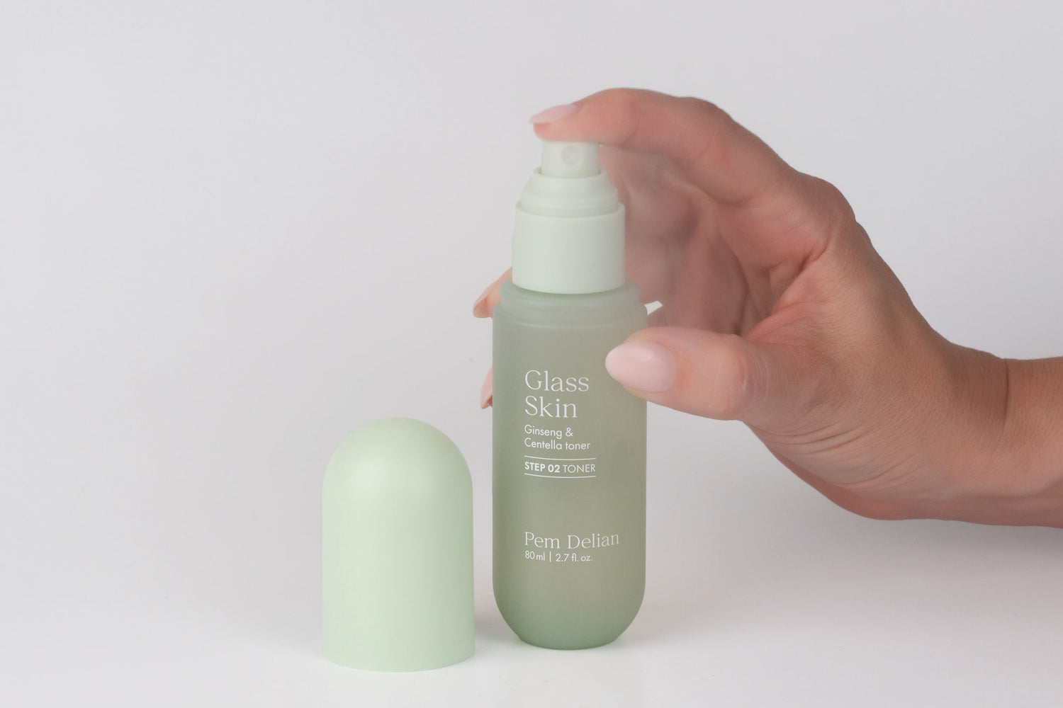 Pem Delian Glass Skin Ginseng & Centella toner permetezve, modell keze lenyomja a pumpát