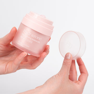 Pem Delian Hydrazone vízbázisú arcápoló zselé a modell kezében, másik kézben a tégely teteje