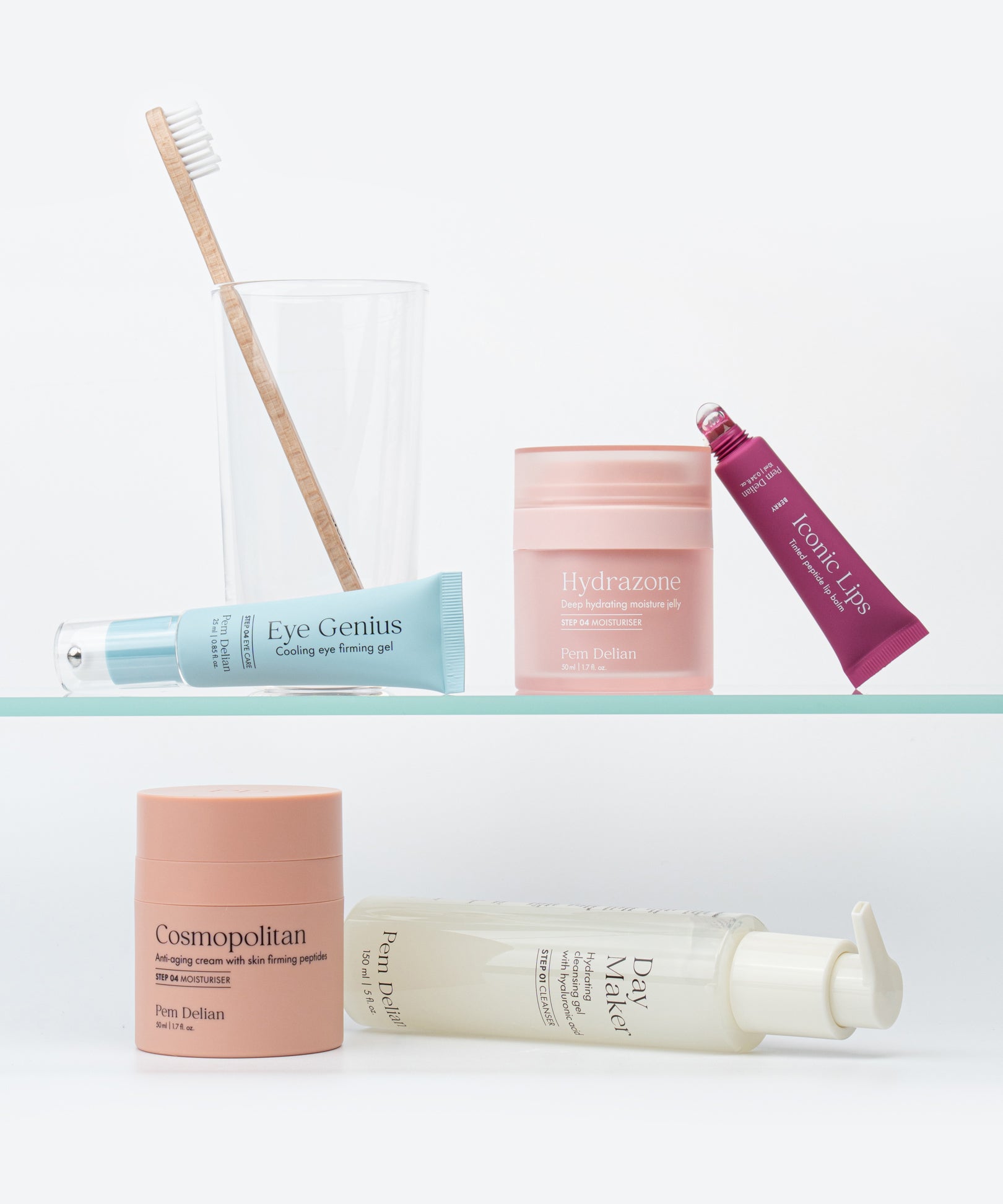 Pem Delian Hydrazone arckrém egy üveg polcon, mellette különböző fajta termékek és egy pohár, benne fogkefe