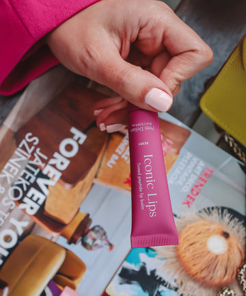 Iconic Lips berry színezett peptides ajakápoló modell kezében, magazin háttér előtt