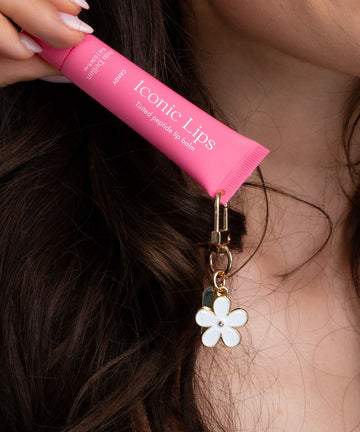 Pem Delian Iconic Lips candy színezett, peptides ajakápoló virágos charmmal
barna hajú modell kezében