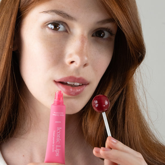 Pem Delian Iconic Lips candy színezett, peptides ajakápoló és nyalóka vörös hajú modell kezében