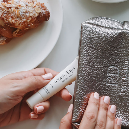 Pem Delian Iconic Lips clear peptides ajakápolót neszeszerből kiveszik, mellette tányéron péksütemény