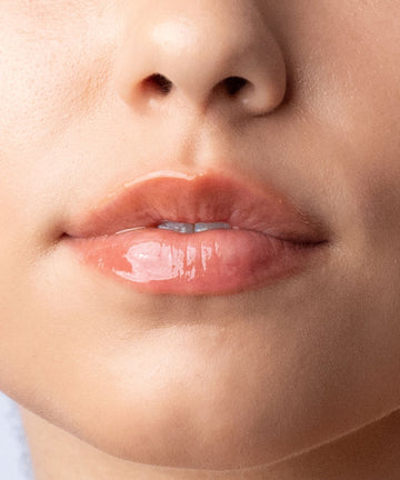 Pem Delian Iconic Lips clear peptides ajakápoló vanília aromával szájra felkenve

