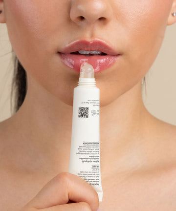 Pem Delian Iconic Lips clear vanília ízű peptides ajakápoló tubusból kinyomva a száj előtt
