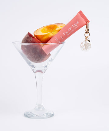 Pem Delian Iconic Lips coral színezett, peptides ajakápoló kagylós charmmal, barackkal pohárban