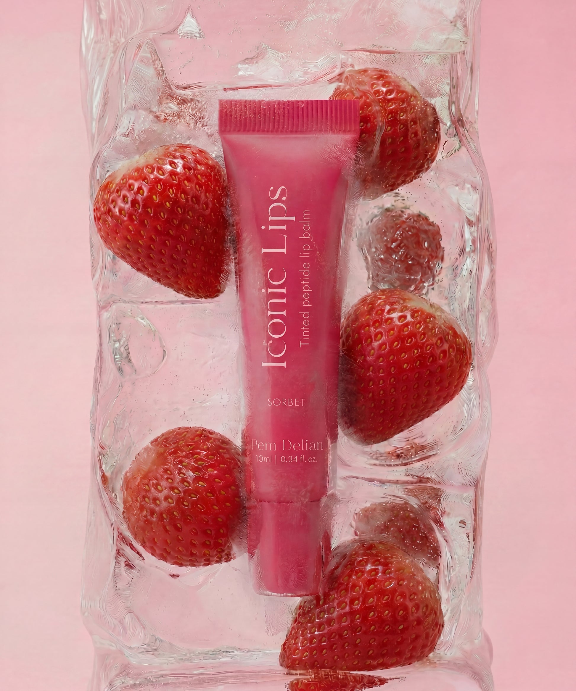 Pem Delian Iconic Lips sorbet ajakápoló jégbe fagyasztva eprekkel rózsaszín háttér előtt 
