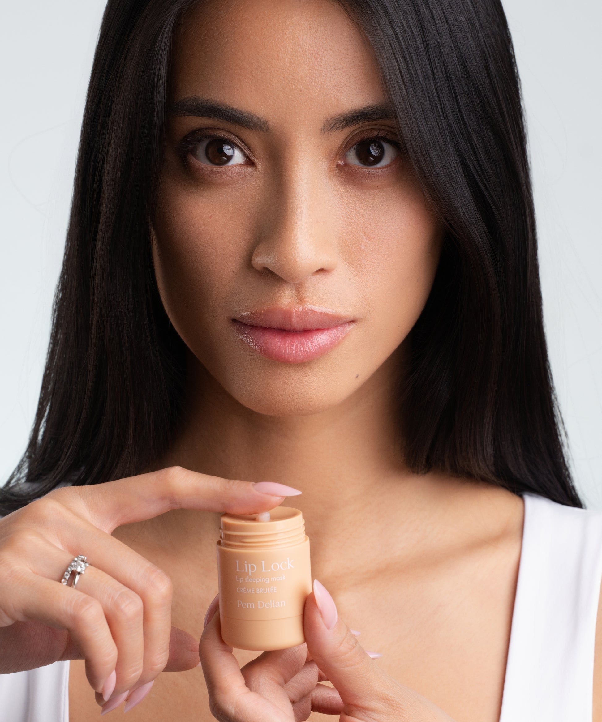 Pem Delian Lip Lock Créme Brulée éjszakai ajakápoló maszk modell kezében tartva kikenve