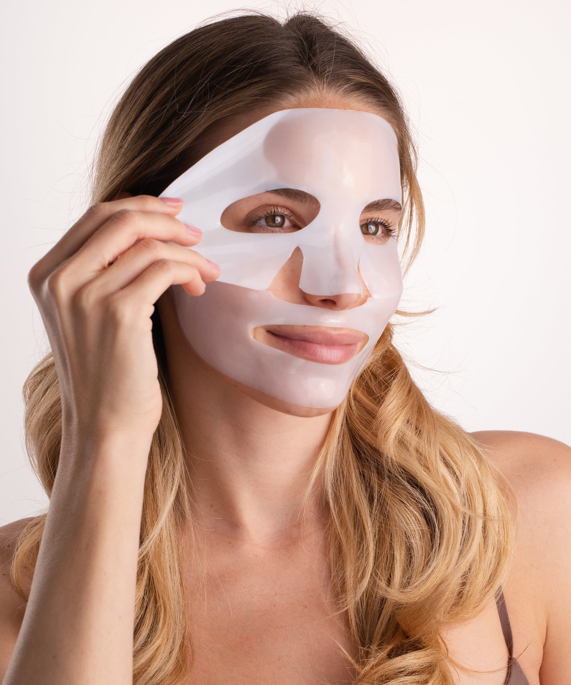 Pem Delian Lumiskin arcmaszk modell arcára téve egyik kézzel tartva a maszk szélét