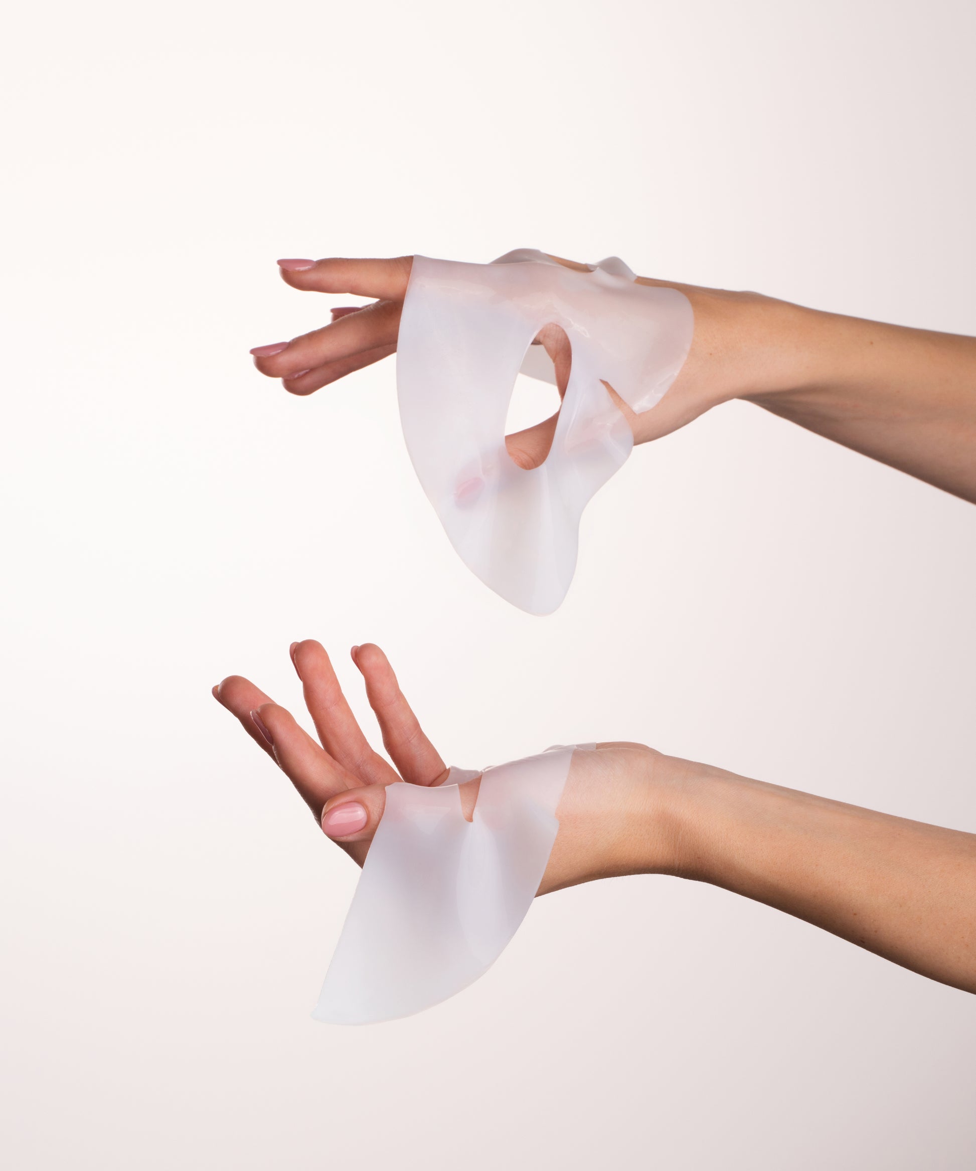 Pem Delian Lumiskin arcmaszk két kézben tartva az alsó és felső részét kicsomagolt állapotban 