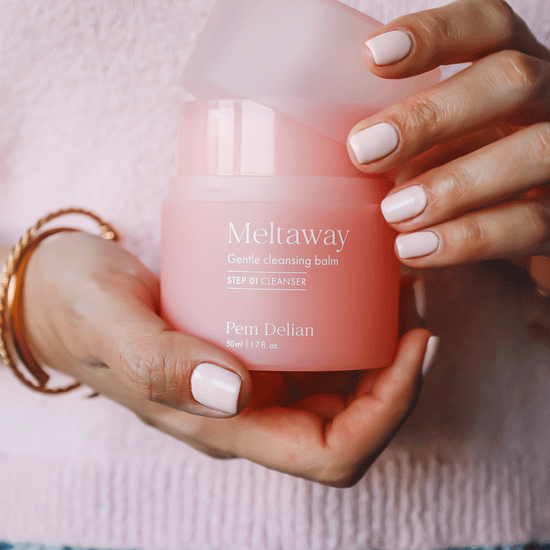 Pem Delian Meltaway arctisztító kézben tartva, kupakja leemelve