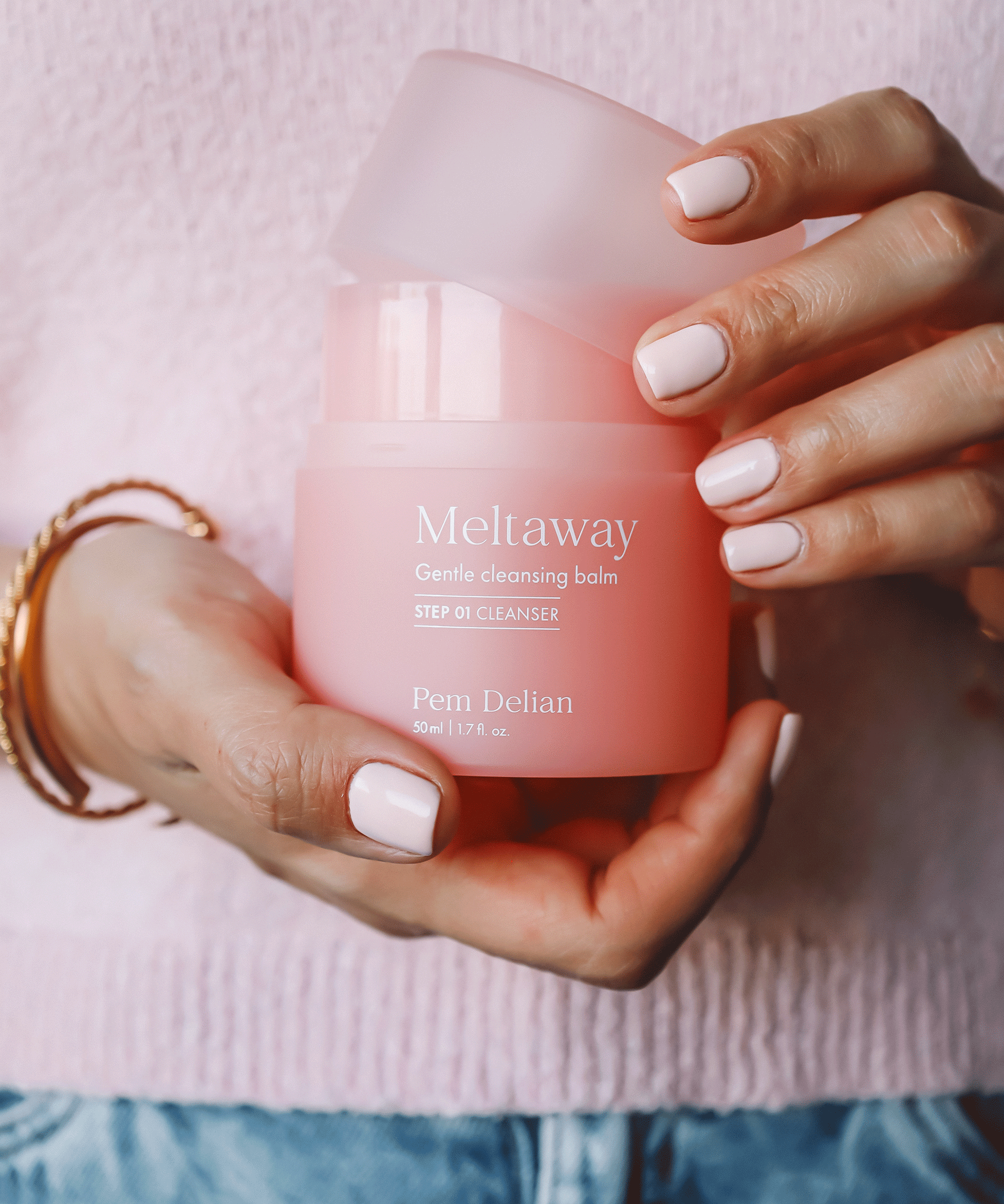 Pem Delian Meltaway arctisztító kézben tartva, kupakja leemelve