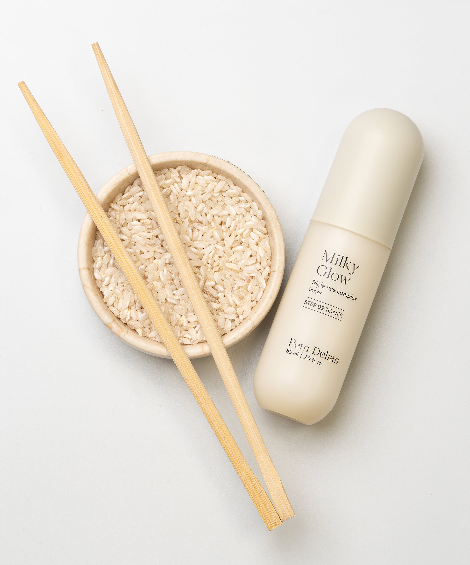 Pem Delian Milky Glow toner egy tál rizs és pálcikák mellé fektetve fehér háttérrel