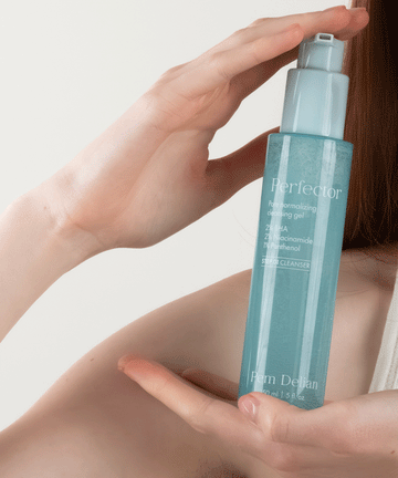 Pem Delian Perfector pórusnormalizáló arctisztító gél modell kezében tartva arc mellett