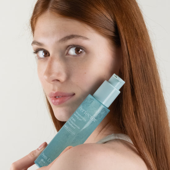 Pem Delian Perfector pórusnormalizáló arctisztító gél modell kezében tartva arc előtt