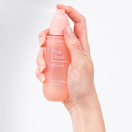 Pem Delian Pink Cloud NMF & Glycoin Ultra hidratáló toner modell kezében tartva, pumpálva permetez