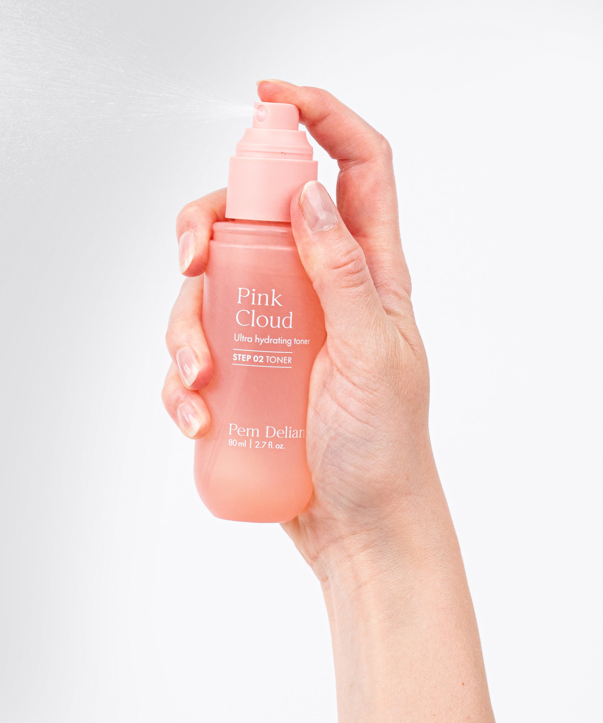 Pem Delian Pink Cloud NMF & Glycoin Ultra hidratáló toner modell kezében tartva, pumpálva permetez