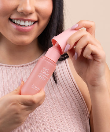 Pem Delian Pink Cloud NMF & Glycoin Ultra hidratáló toner a modell arca mellett, egyik kezével a terméket fogja, másikkal a kupakot veszi le