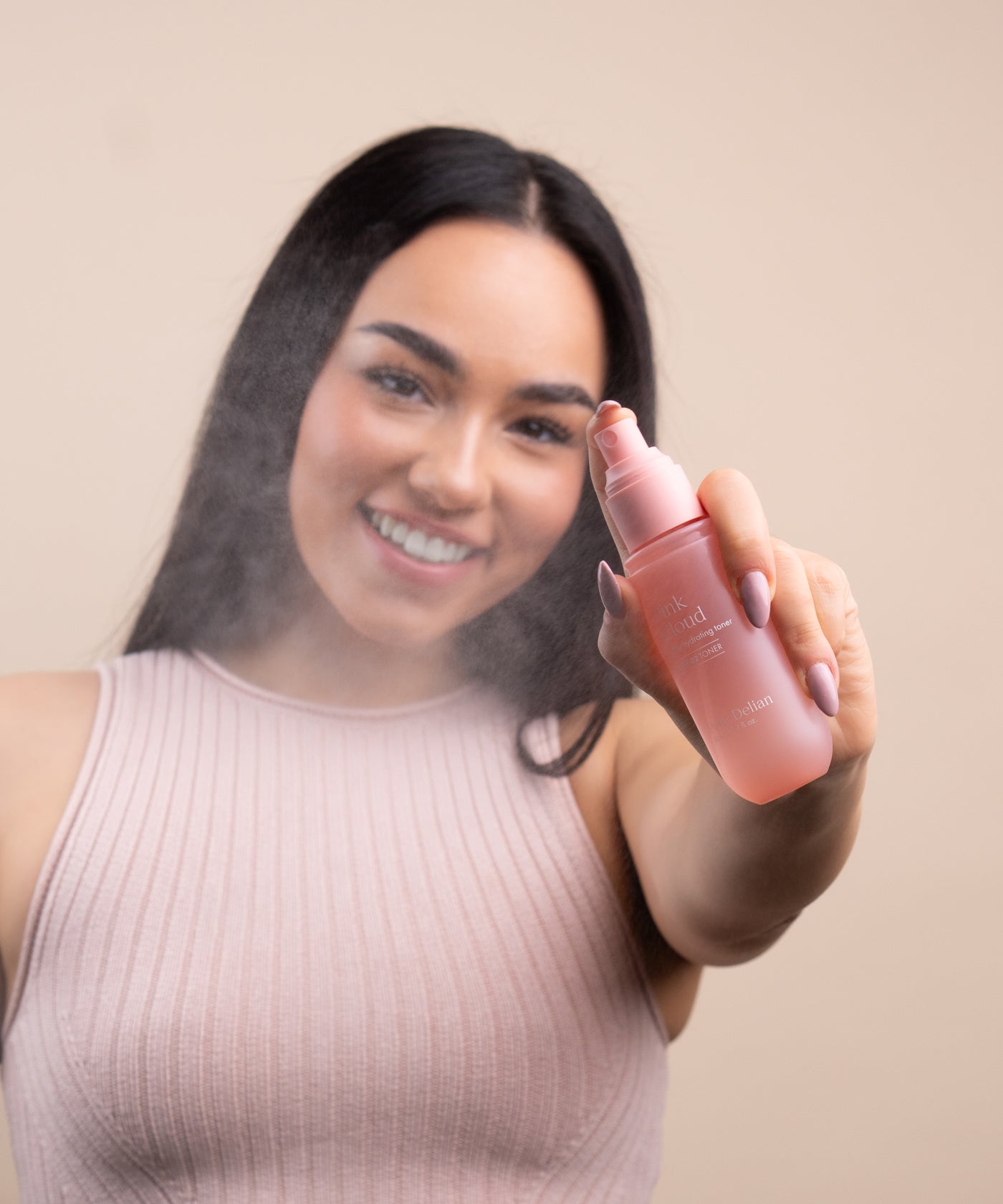 Pem Delian Pink Cloud NMF & Glycoin Ultra hidratáló toner permetezve a modell arca előtt