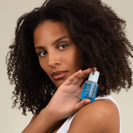 Pem Delian kék színű Purist 10% Niacinamide+ 3 PCA multiszérum a modell kezében a vállán