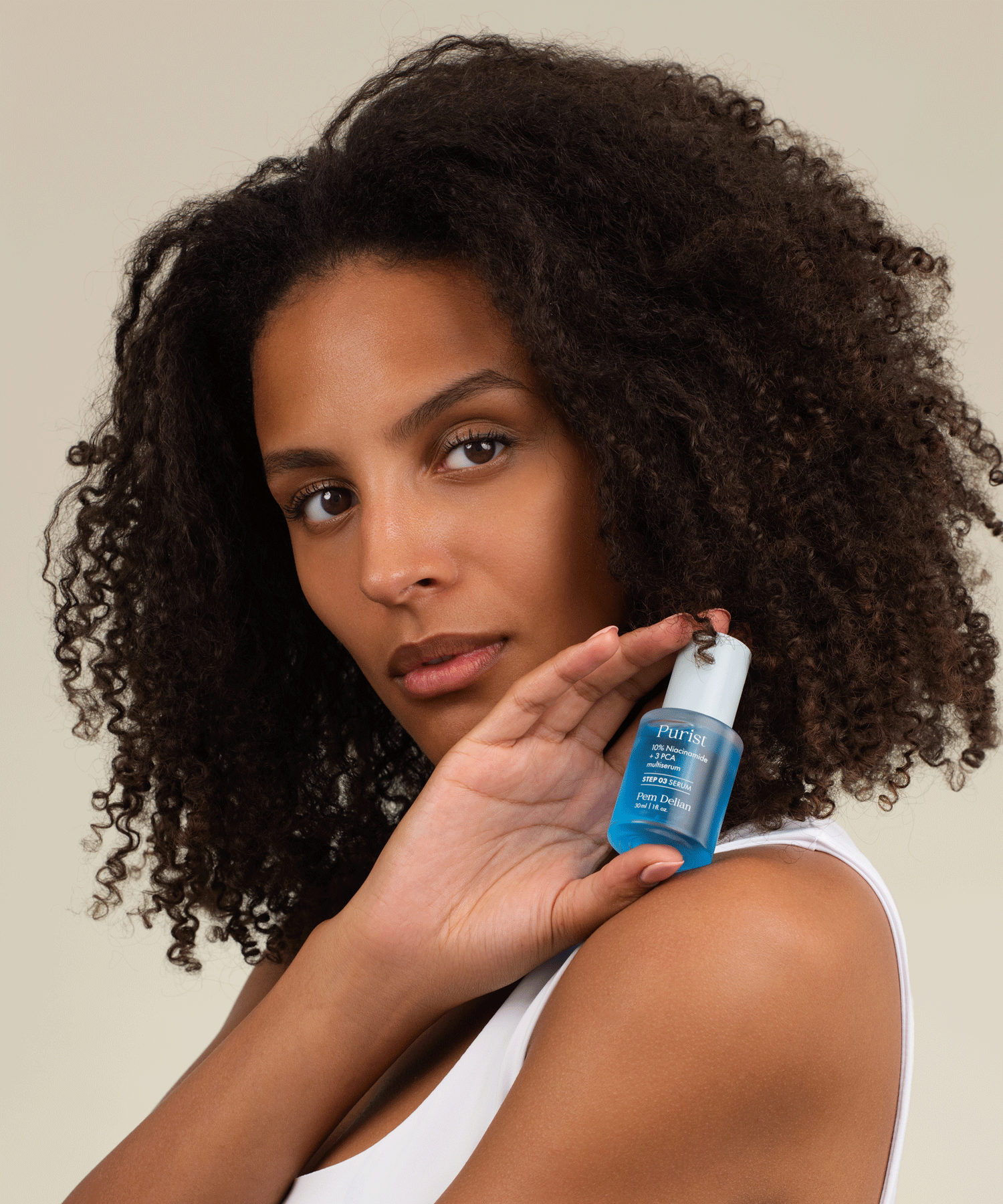 Pem Delian kék színű Purist 10% Niacinamide+ 3 PCA multiszérum a modell kezében a vállán