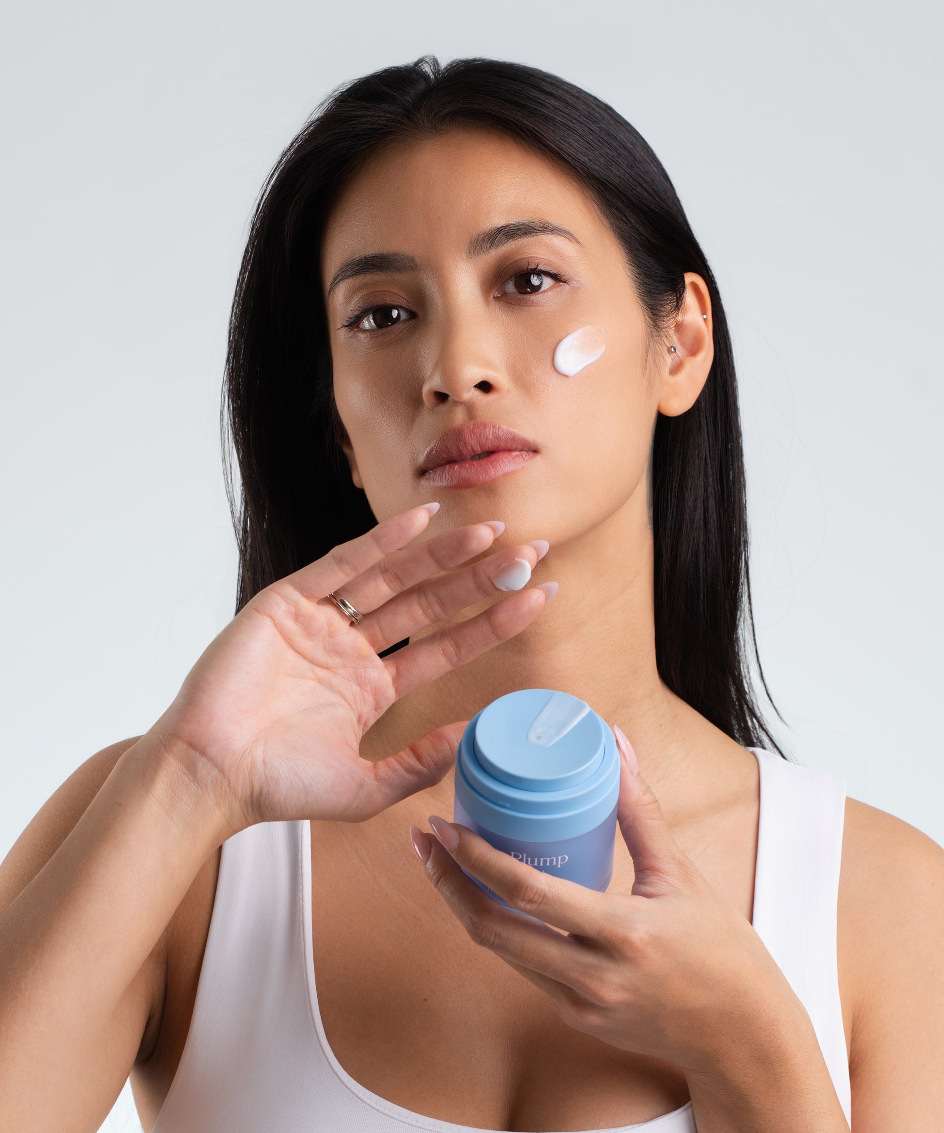 Pem Delian Water Plump modell kezében tartja, textúra az arcon