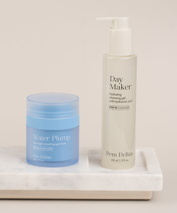 Pem Delian Water Plump éjszakai hidratálókrém egy márvány mintás tálcán, mellette Day Maker arclemosó